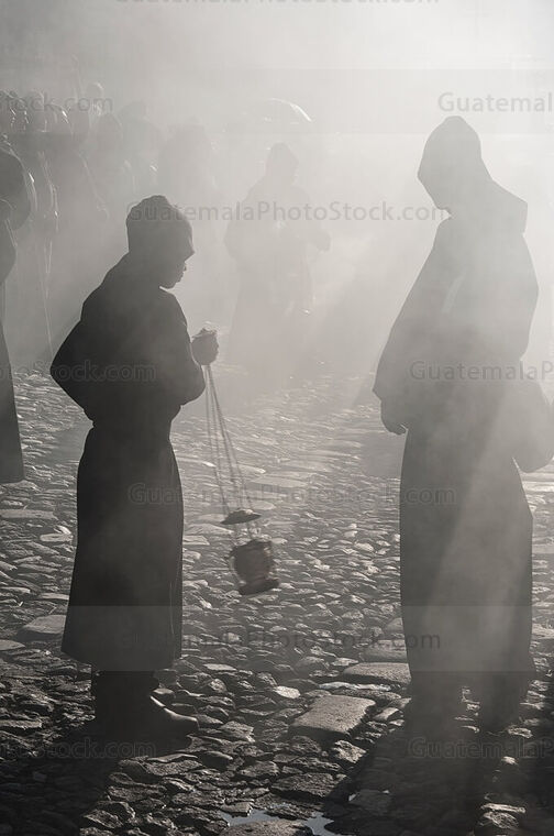 Cucuruchos entre el humo del incienso que precede el anda procesional