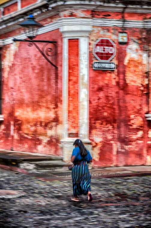 Mujer corre en las calle empedradas de Antigua